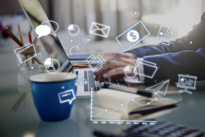 What is digital marketing? A professional working on a laptop with digital marketing icons including email marketing, analytics, social media, online communication, sales growth, and business performance metrics displayed around the screen.